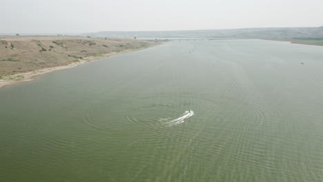 water skier on the river being pulled by a speedboat at saskatchewan landing provincial park in canada