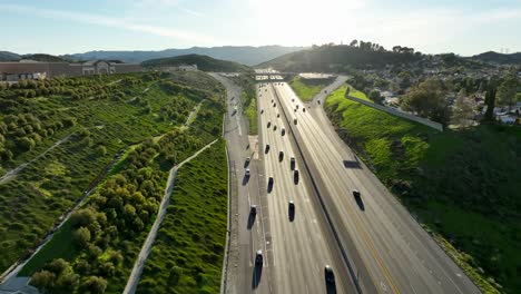 Santa-Clarita-Antelope-Valley-freeway,-aerial-above-passing-cars-during-bright-afternoon
