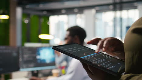 close up of programmer utilizing ai on tablet to optimize performance