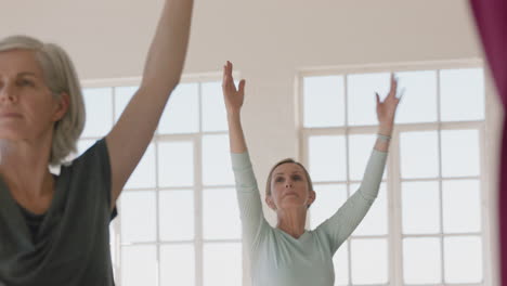 Clase-De-Yoga-Hermosa-Mujer-Madura-Practicando-Pose-Guerrera-Meditación-Disfrutando-De-Entrenamiento-Físico-En-Grupo-En-El-Estudio