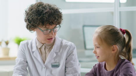 female pediatrician working with little girl in clinic