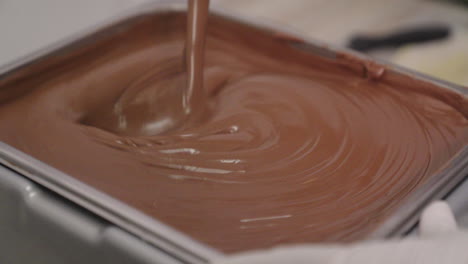 stirring thick melted brown chocolate with a ladle, slow motion