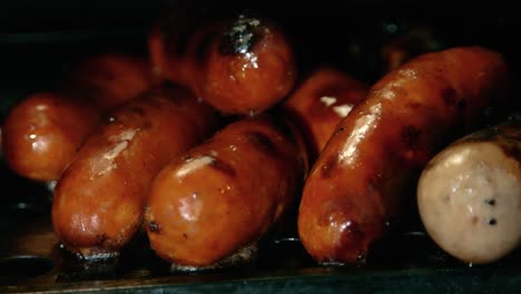 cooked pork sausages lying on warming grate of bbq after cooking