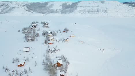 an eagle-eye drone shot of the snow-covered mountains and houses in villages in the perfect winter escape in park city, utah