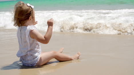 cute young girl paddling in the surf