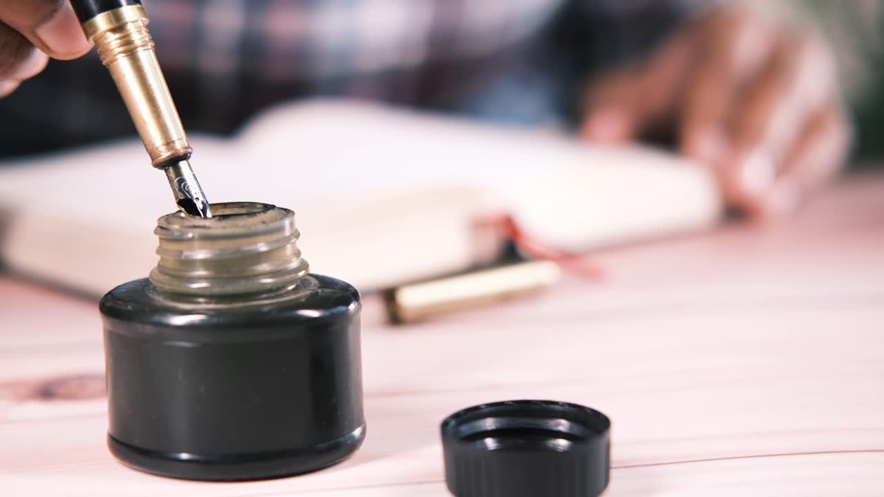 persona que escribe con una pluma pluma