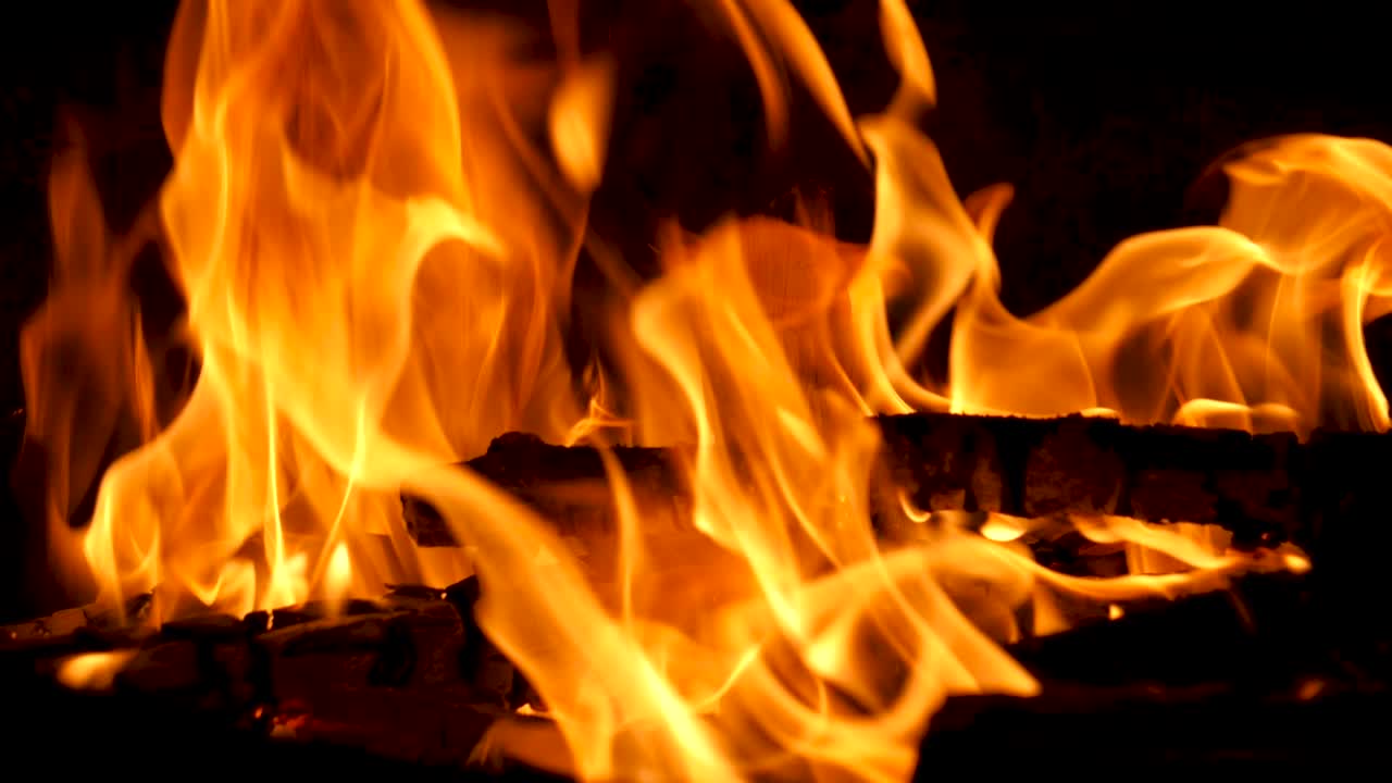 cerrar las llamas del fuego en cámara lenta - chimenea oscura y troncos cu 180fps