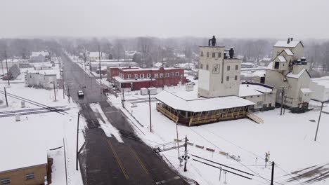 industrial buildings of small usa town covered in snow, aerial orbit view