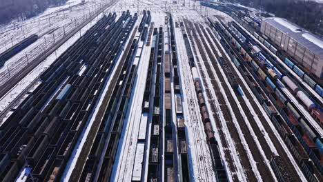 de longues lignes droites de trains de marchandises dans le dépôt ferroviaire de katowice en pologne - révélation aérienne par drone - lignes de chemin de fer couvertes de neige en hiver