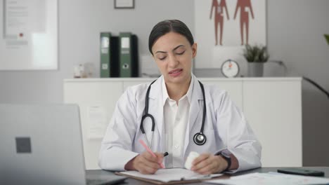 sad indian female doctor giving medicine to patient