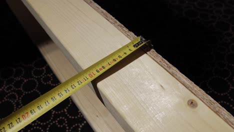 close-up of a tape measure on wood, marking precise measurements for construction.