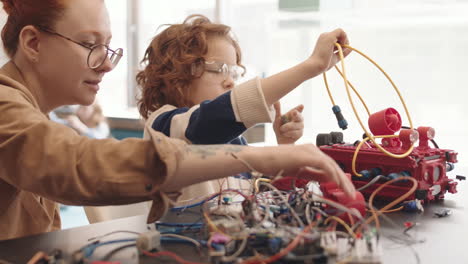 adult and child building a robotics project in a workshop
