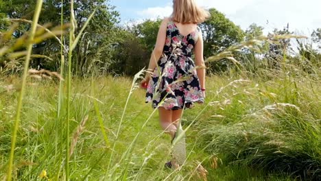 woman walking on green field 4k