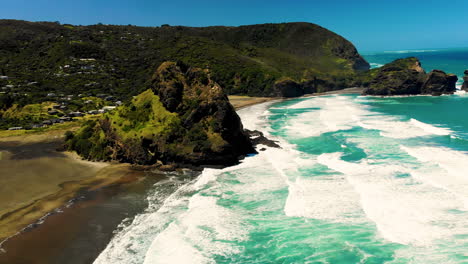 ocean waves crashing volcanic rock formation on new zealand coastline, piha