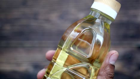 botella de aceite de cocina en la mano