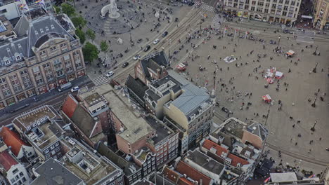 amsterdam netherlands aerial v12 birds eye view drone fly around busy dam square capturing national monument and dutch architectures at binnenstad neighborhood with sun shining through - august 2021