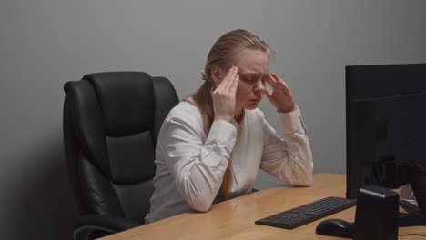 woman with headache at her desk