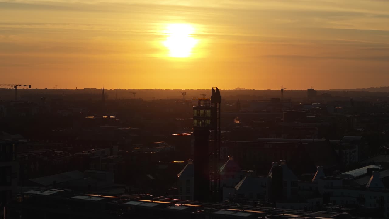 Filmagem cinematográfica de drone em 4K, de tirar o fôlego, capturando o mágico nascer do sol na hora dourada sobre a Skyview Tower, Dublin, Irlanda_40