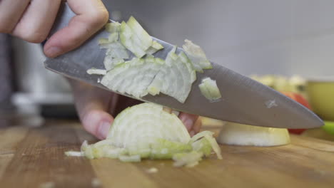 close, slow motion shot onion on chopping board sliced up with a knife, healthy diet