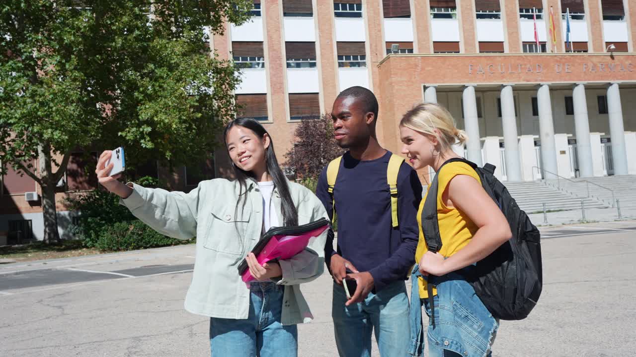 Grupp studenter som tar en selfie på campus