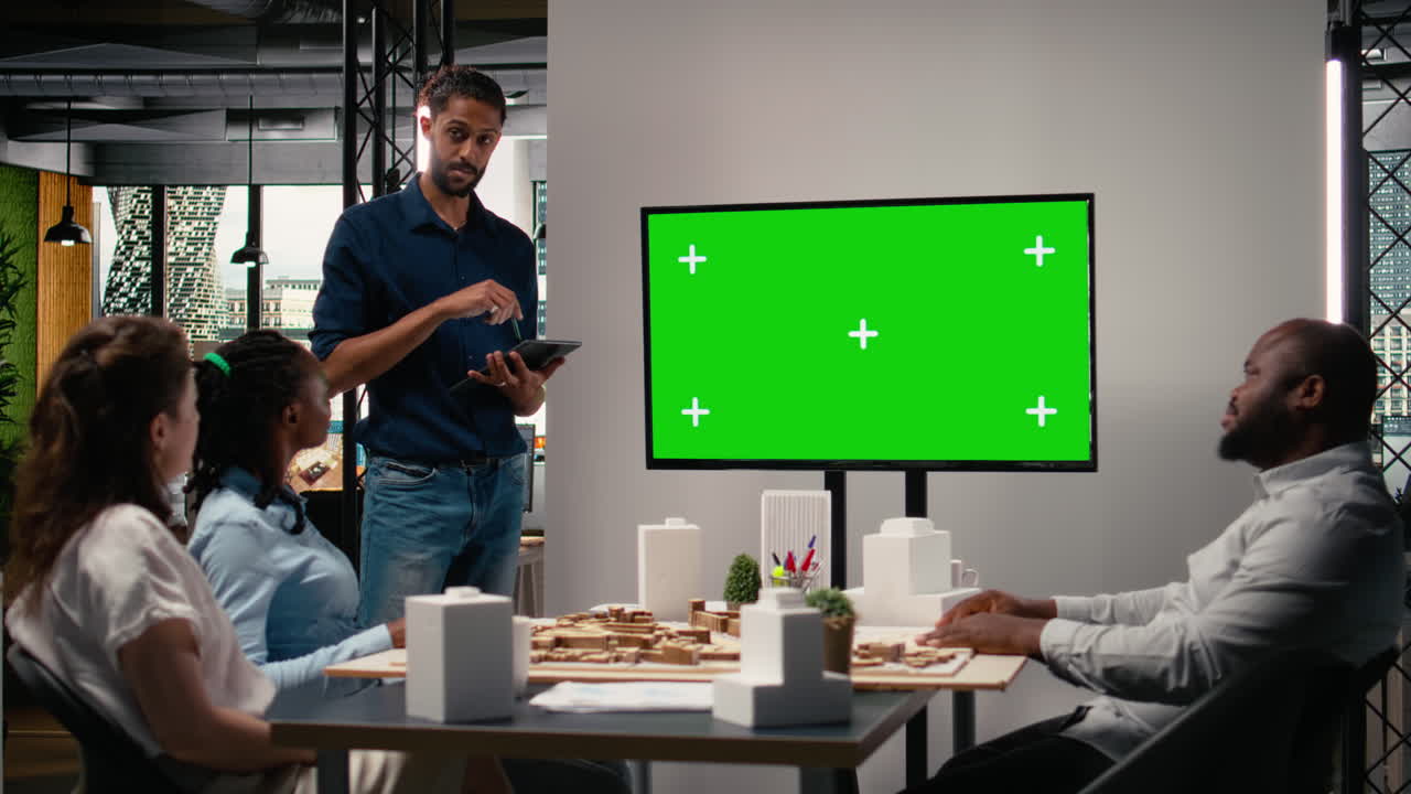 Real estate diverse team review architectural models with copy space TV