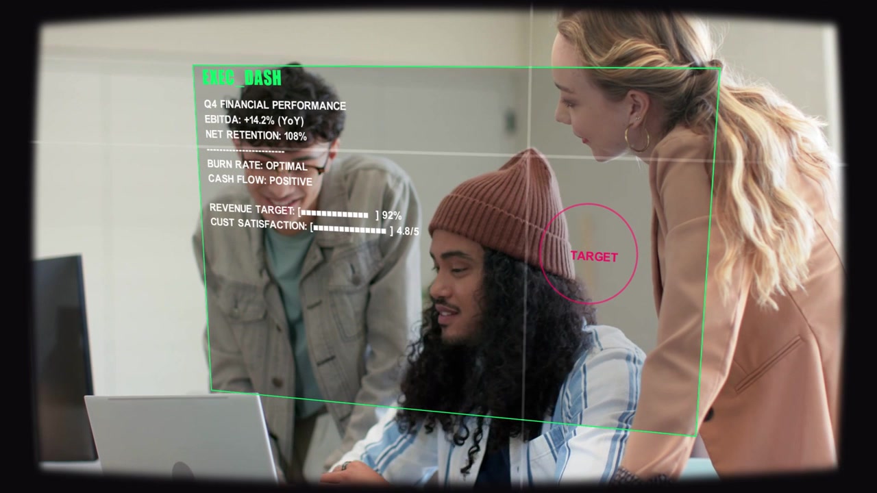 Green HUD appearing spurring 3-person team reviewing laptop dashboard aiming at red TARGET marker