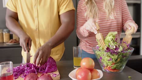 Happy-diverse-group-of-friends-preapring-meal-in-kitchen,-slow-motion