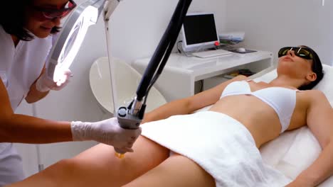 doctor performing laser hair removal on patient skin