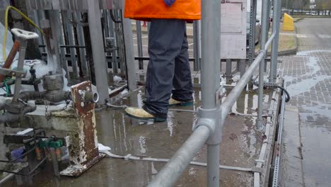 worker in protective suit working at dangerous construction site area - handheld shot