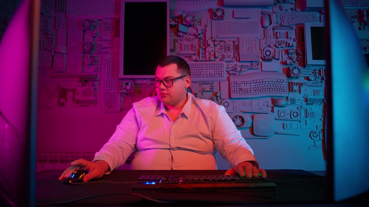 Mann spielt Computerspiele in einem neonbeleuchteten Raum