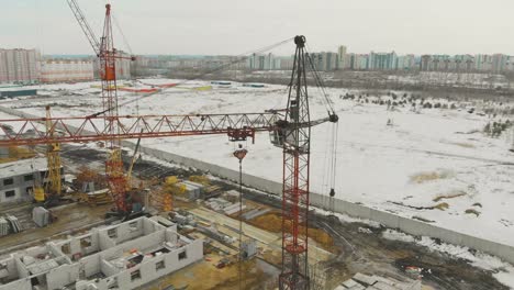 grúas de construcción anaranjadas en el sitio de construcción contra el campo