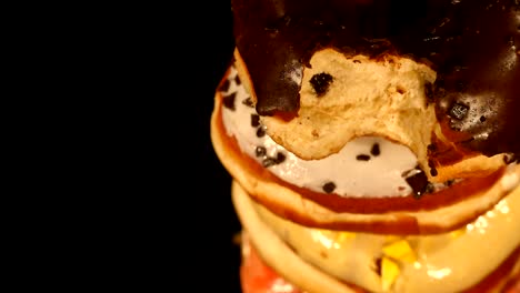 different colored donuts with different fillings rotating on a black background