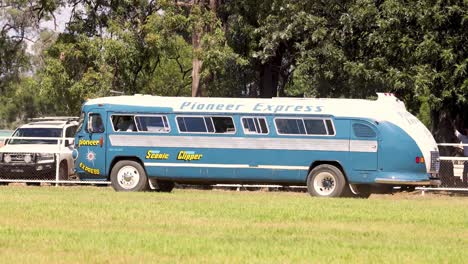 old-fashioned bus driving through a grassy area