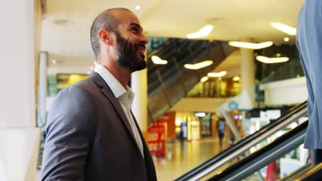 Business-people-interacting-on-an-escalator