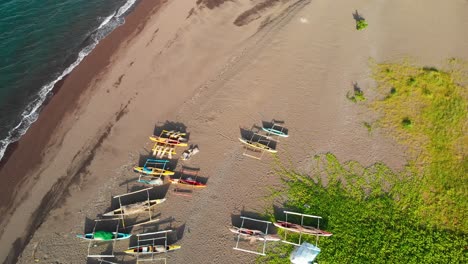 antena de drones de botes bomba de pesca en una playa de arena mientras las olas llegan a tierra en un día soleado