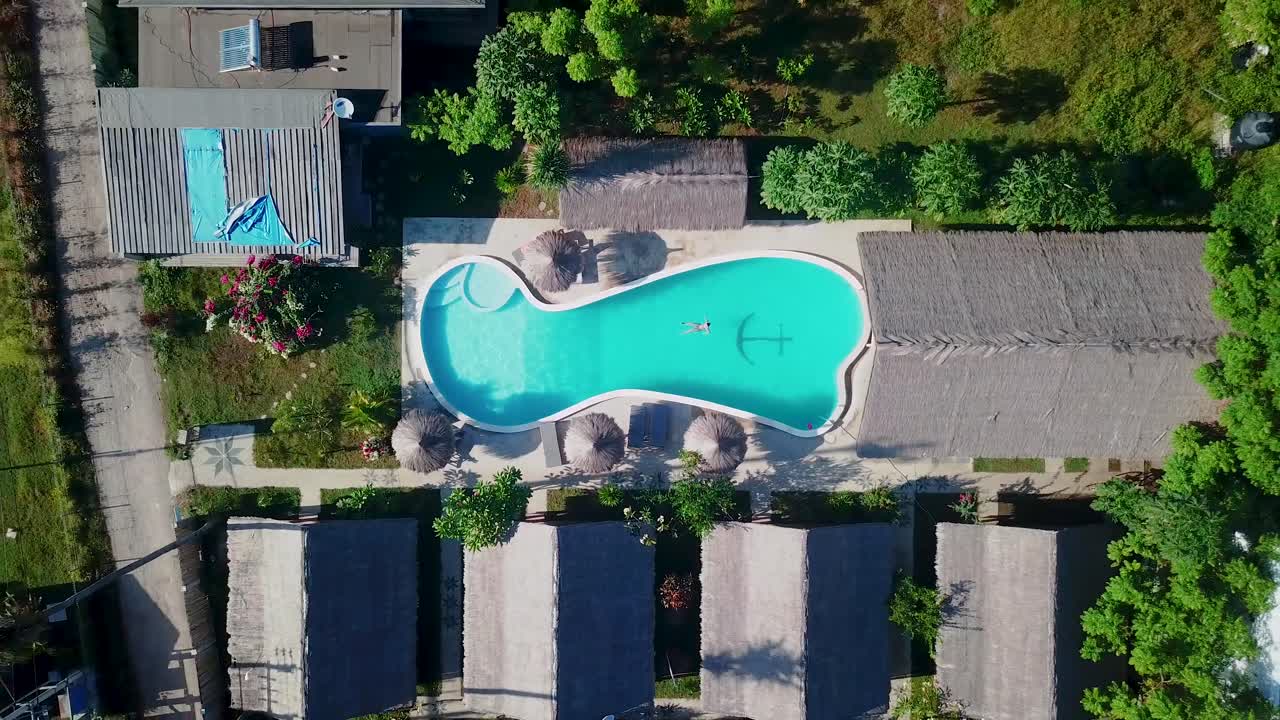 Pige svømmer i en pool på en tropisk ø