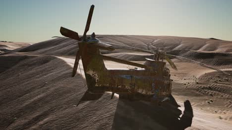 old rusted military helicopter in the desert at sunset