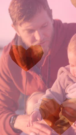 animation of heart icons over caucasian father with child at beach