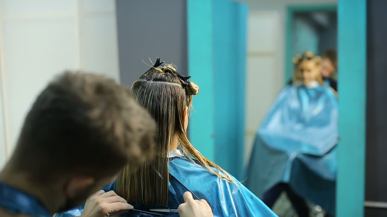 Hairdresser cutting hair of her customer at the hairdressing salon