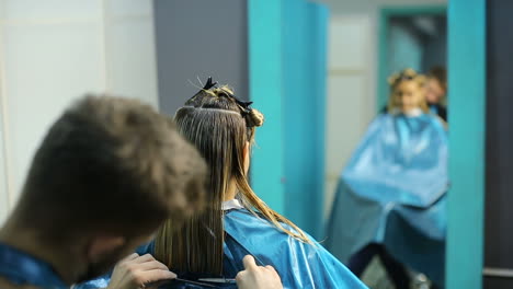 hairdresser cutting hair of her customer at the hairdressing salon