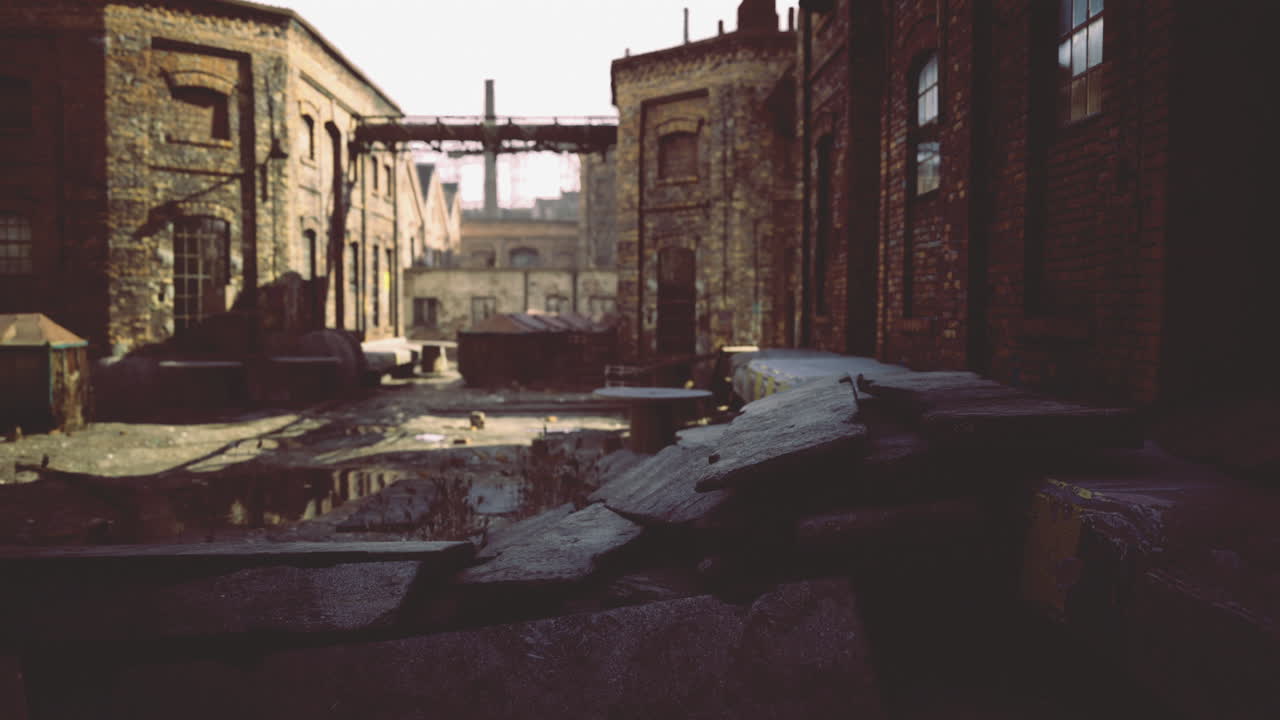 Industrial alleyway with old buildings and puddles in the early morning light