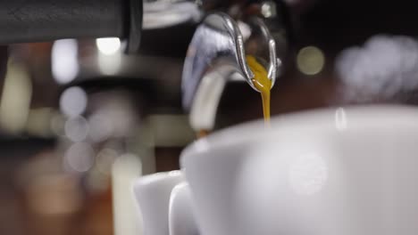 close up of espresso flowing into two espresso cups