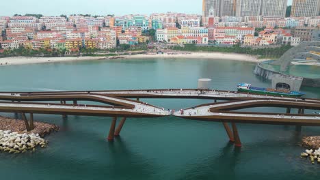 aerial view of a modern bridge over water, colorful buildings in the background