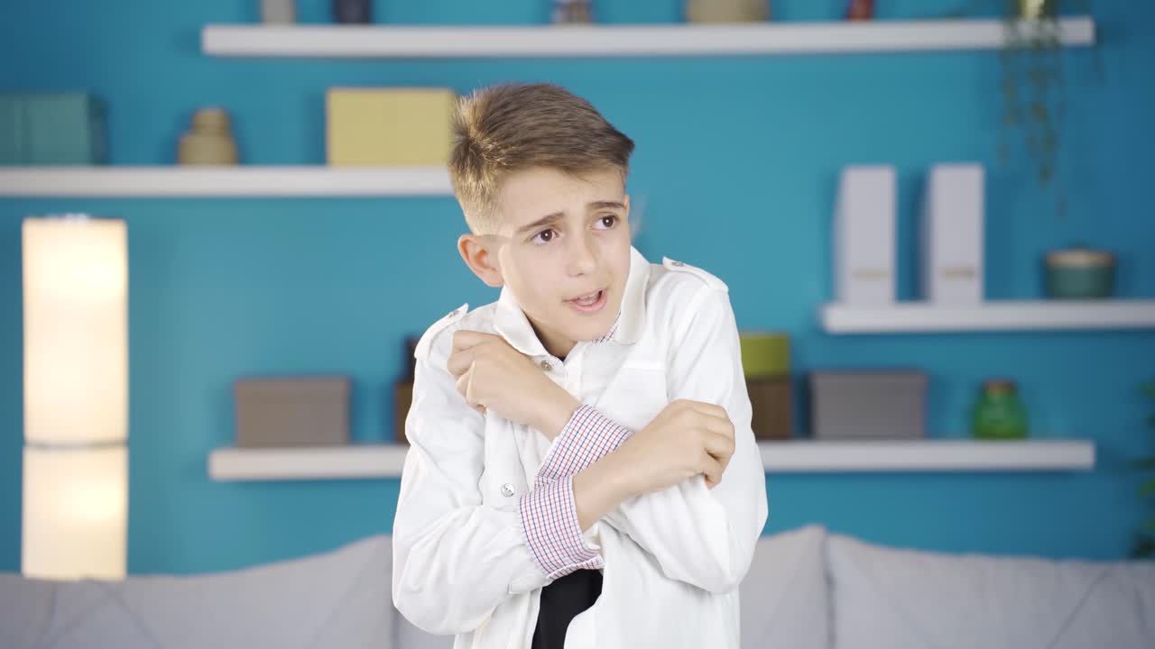 소년은 두려움과 불안으로 카메라를 쳐다보고 있습니다.