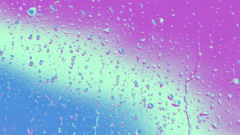 primer plano de gotas de lluvia iridescentes que fluyen sobre el vidrio de la ventana