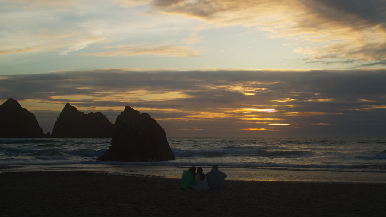 Splendido tramonto con turisti in vacanza sulla spiaggia sabbiosa di Holywell Bay Beach in Cornovaglia, Inghilterra.