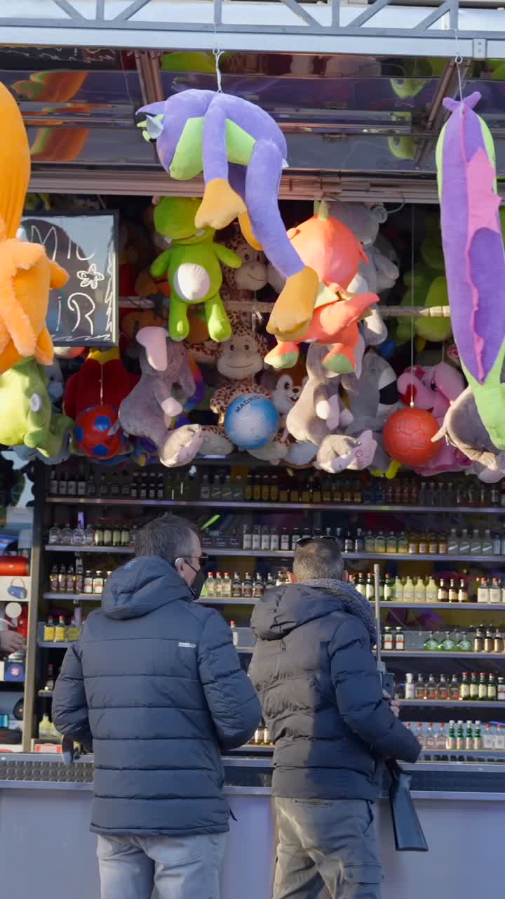 A game booth at a carnival with stuffed animal prizes and shelves of small bottles