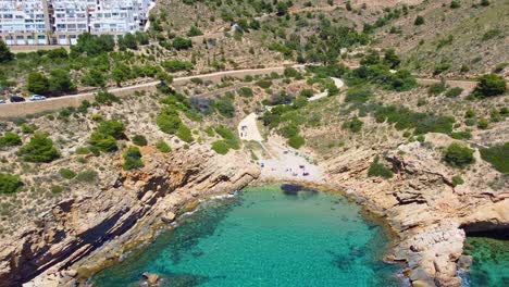 Tourist-In-Cala-Tio-Ximo-Mit-Rustikalem-Gelände-Und-Ruhigem-Blauem-Meer-Im-Sommer---Villa-Marina-Apartment-Buildings-In-Benidorm,-Alicante,-Spanien