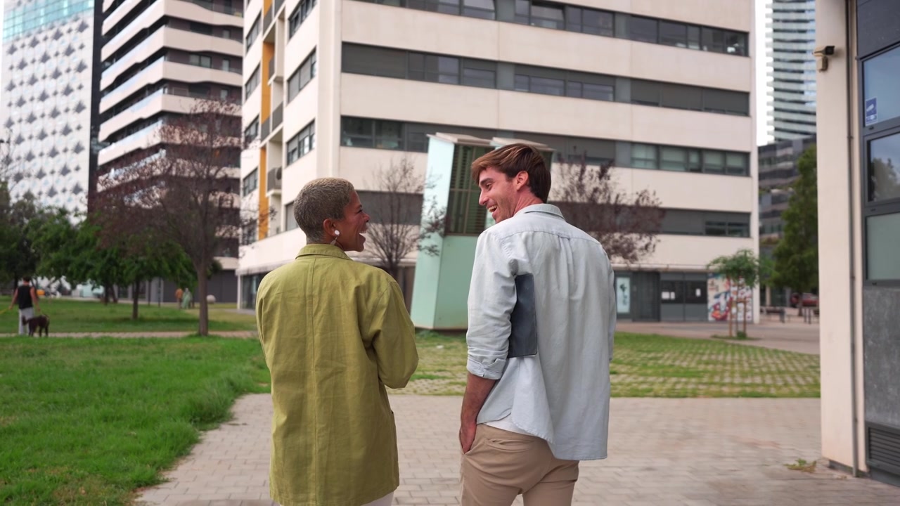 Dos jóvenes caminando y conversando juntos al aire libre