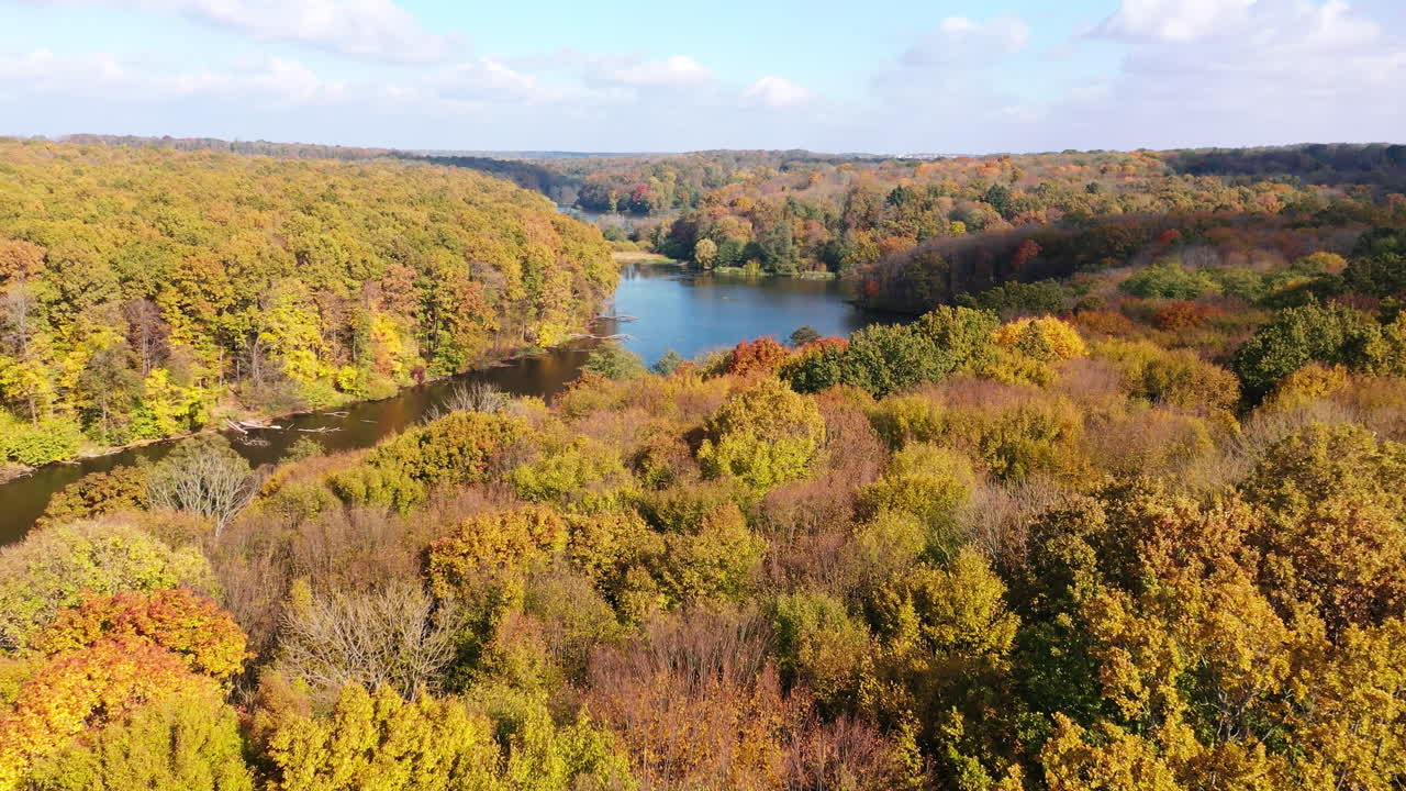 Amazing view over the woodlands on sunny day. Autumn season in thick woods. Beautiful sky reflecting in the river.